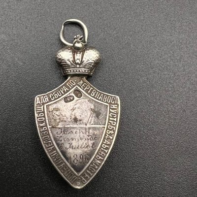 Commemorative donation badge “For the Collection of Charitable Contributions of the Community of Sisters of Mercy and for Establishing Shelters for the Homeless” (Russian Empire, 1896).